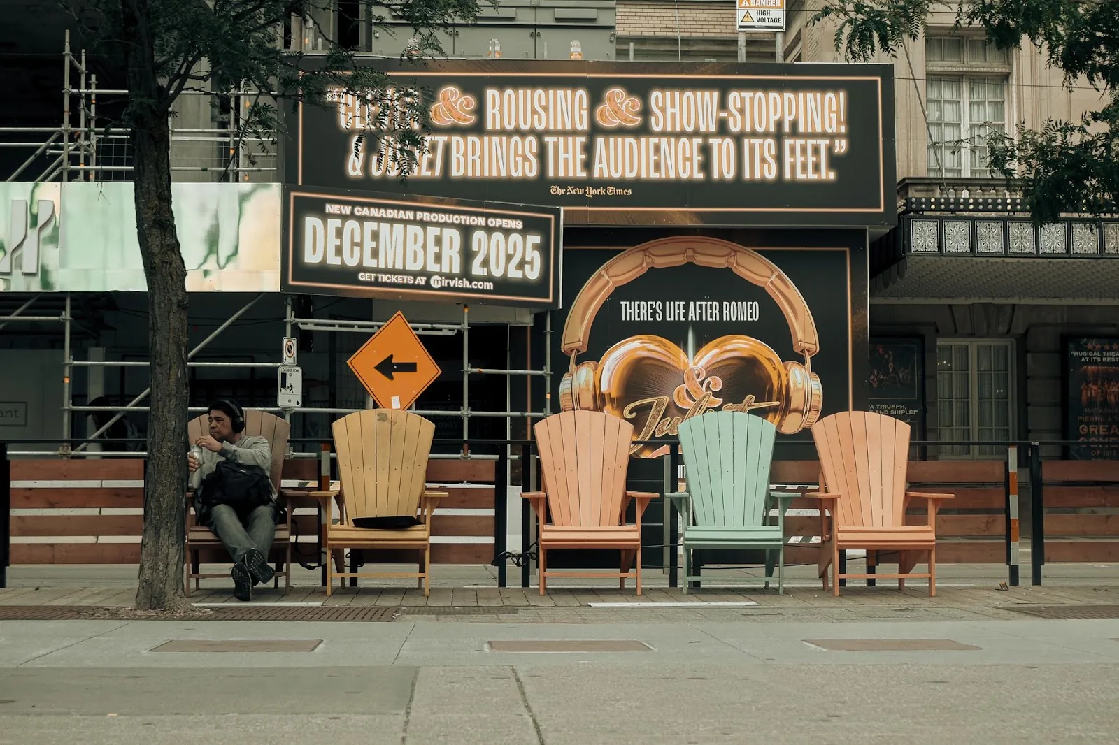Urban street scene with colorful chairs and advertising sign. People enjoying a moment of rest.