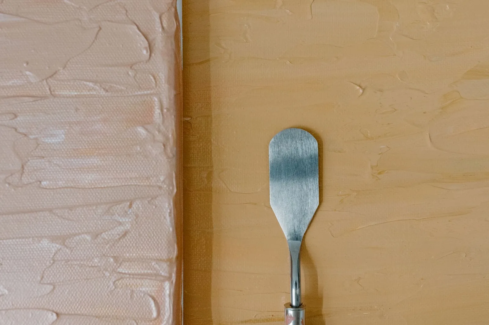 Detailed view of a textured canvas with palette knife on a neutral background, perfect for art concepts.
