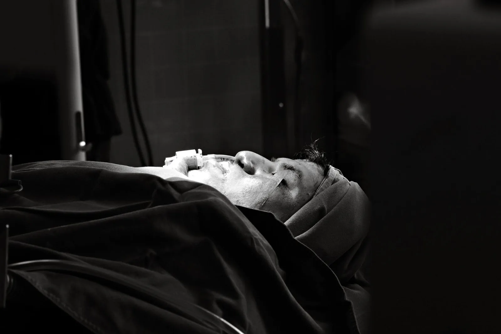 A patient lies in an operating room under surgical lights, creating a dramatic healthcare scene.